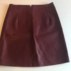 Vinröd ”skinnkjol” - Aldrig använd och kan inte få på mig den längre :) köparen står för frakt. Nypris 300kr