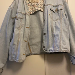 Vintage Jeansjacka  - Säljer min jeansjacka , som jag köpt secondhand för ett antal år sedan. Färgen är urtvättad ljusblå med blomdetalj. Passformen är oversize överlag , och passar både S, M och L beroende på hur man vill att den ska sitta. Frakt ingår i priset ☀️