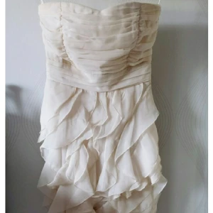 Klänning - Jättefin klänning med volanger. Krämvit. Aldrig använd. Från VILA. Inköpspris 499kr. 