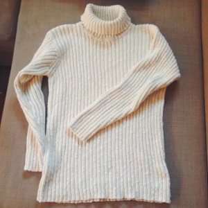  - Grovstickad polotröja i en fin benvit färg, från Adelsten. Normal i storlek. Knappt använd och väldigt bra kvalité 🌷