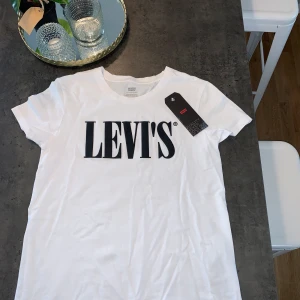 Oanvänd Levi’s T-shirt - Hej! Nu säljer jag min vita Levi’s t-shirt med svart tryck i storleken xs för 100kr. Tyvärr passa den inte på mig så jag hoppas att någon annan får användning för den!☺️ Den är helt oanvänd och har endast legat i förpackningen som den kom i. Du får gä