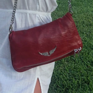 Röd Zadig väska - Säljer min röda väska från Zadig&Voltaire i den härligaste röda färgen. Modellen heter Rock Crush. Den är i superfint skick då jag inte fått så mycket användning för den! Dustbag tillkommer och både det långa och korta bandet. Nypris: 3545z