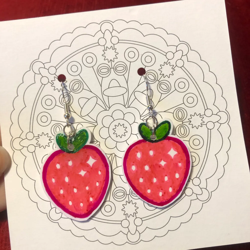 Örhängen föreställande jordgubbar gjorda av krympplast 🍓. Aldrig använda såklart. Frakt tillkommer på 11 kr.💕. Accessoarer.