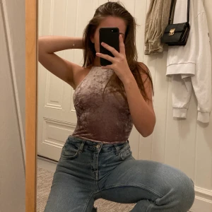 Lila Bodysuit - Bodysuit med öppen rygg i lavendel lila färg. Sammetsliknande material och ger en snygg siluette. Går att öppna undertill. Ena bandet på ryggen känns liiite längre än det andra.  Köparen står för frakten (vet ej hur mycket det kommer kosta) och kan mötas upp! 
