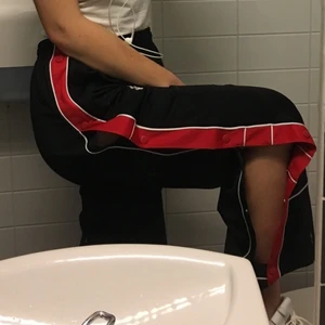 Popperpants - Mina svarta,  fantastiska joggers med knappar längs båda benen. Knapparna går att knäppa upp hela vägen och är i typisk street-anda. Röda och vita detaljer. Står stl M i men är definitivt i stl S/36