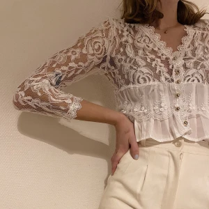 Croppad vit kofta i spets - Fin spetskofta i perfekt skick. Guldiga knappar, trekvartsarmar och fint figursydd i midjan. Går att klä ner med ett par slitna jeans eller klä upp med ett par kostymbyxor. Säljer pga för liten. Är S-M men skulle passa XS-S. Buda i kommentarerna 👸🏼✨💖