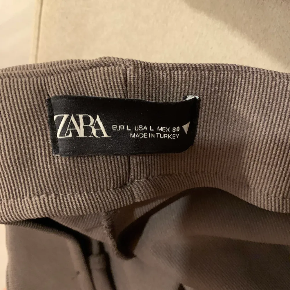 Ett par superfina byxor från Zara med en slits nere vid foten, dem är i storlek L. Aldrig använda!. Jeans & Byxor.