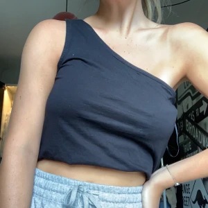Oneshoulder linne från weekday strl M  - Svart linne med en axel. Storlek M, lite rymligare i modellen. Har vikt upp det lite på bilden men de är ju en smaksak ;)) frakt ingår ej 