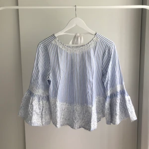 Somrig blus - Somrig blus/topp med spets, volang och knytdetalj. 