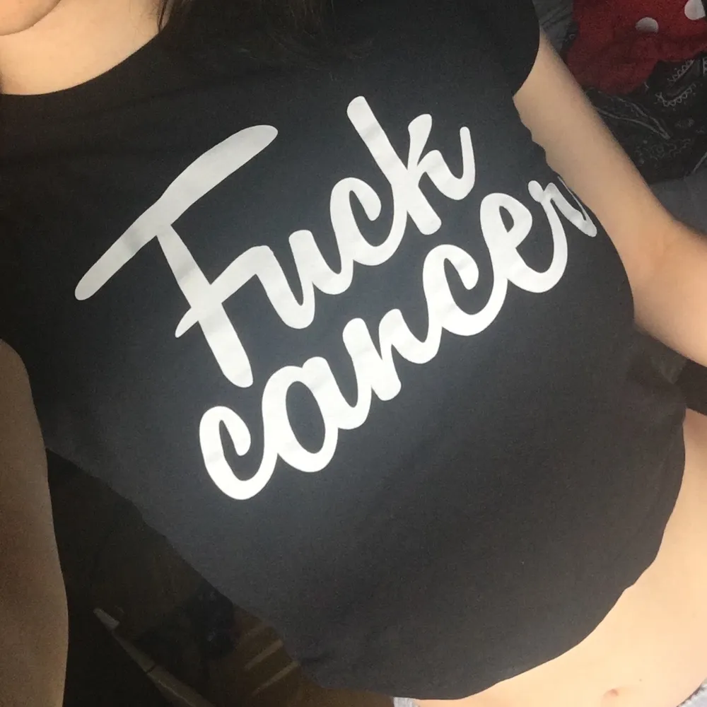 En svart babytee med text ”Fuck cancer” som funkar bra som magtröja, frakt: 22kr. T-shirts.