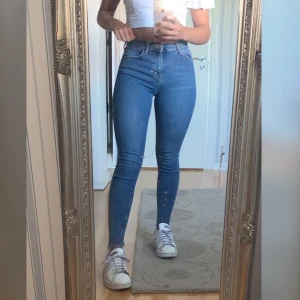 Blå jeans - Blå tajta jeans, ganska stretschiga i bra skick med snygga slitningar i anklarna