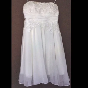  -  En vit spetsklänning men snygg snörning i ryggen, den är axelbandslös , den är endast använd på en skolavslutning.  Nypris 1200kr Vid snabb affär så kan priset diskuteras  