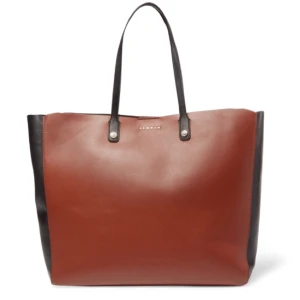  - Skinnväska från Sandro i modellen Adela Tote. Cognacs-brun på fram- och baksida, svart på sidorna och handtagen. Den har ett band på insidan som man kan knyta ihop och på så sätt ändra formen på väskan. Ficka på insidan. Superfint skick, endast använd ett fåtal gånger. Inhandlad i Sandro-butiken på NK i Stockholm. 