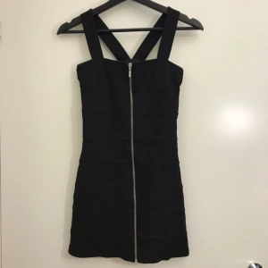  - Svart fodralklänning med dragkedja i silver hela vägen ner på framsidan. Klänningen är i storlek XS. Hämtas i Uppsala eller fraktas till önskad adress. 