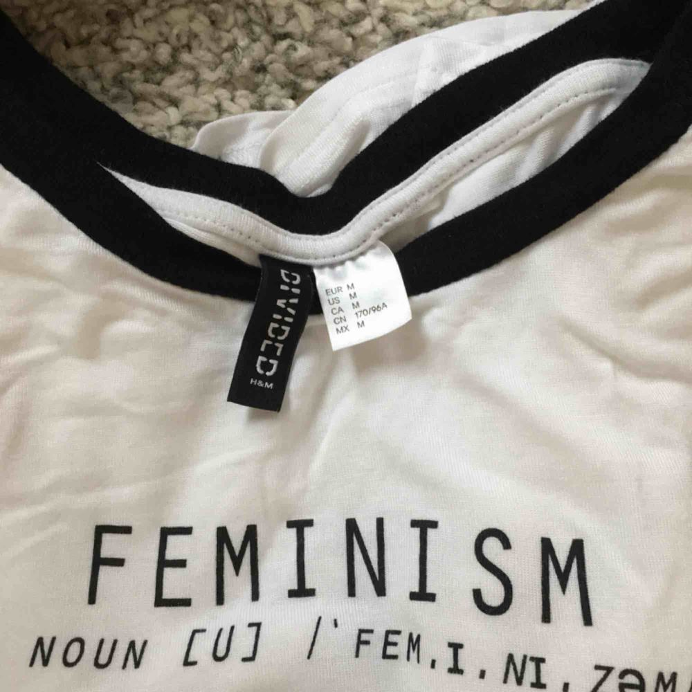 Superhäftig tröja med ”Feminist”-tryck från HM, knappt använd.  Kan möta upp i Lund eller Kristianstad, annars står köparen för frakt.. T-shirts.