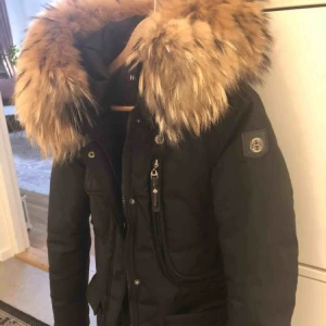  - Svart hollies vinterjacka med en stor svart äkta pälskrage i mycket bra skick. Jackan är varm och som ny. Jättefin jacka säljer pga jag köpt ny jacka. Storlek 36, XS/S. Köpt för 4400..