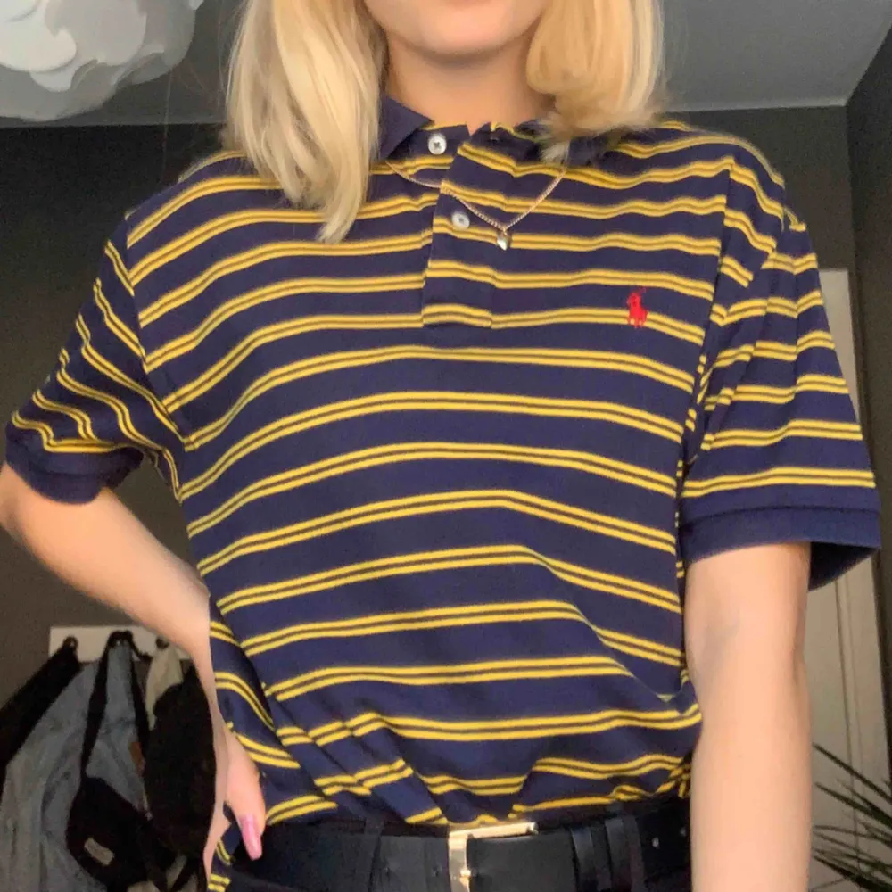 Mörkblå- och gul-randig piké från Ralph Lauren. Väldigt lång i modellen men är väldigt snygg att stoppa in eller klippa av!! . T-shirts.
