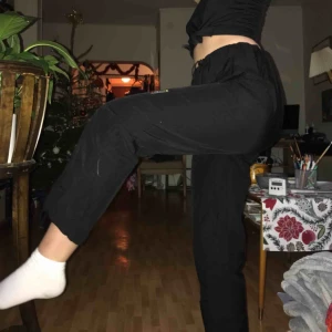  - byxor med ”resår” i midja och vid anklarna . Tunt material, svarta. 