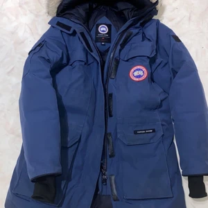 Canada Goose expedition parka - Canada Goose Expedition Parka är en rejäl vinterparkas som värmer även vid extrema väderförhållanden och vinteraktiviteter. Du behöver aldrig mera frysa!! Äkta päls på luvan. Muddar vid ärslut (som bilden visar) ser ut som nya, använd fåtal gånger därav det fina skicket. Kan skicka flera bilder och självklart kan äktheten styrkas.                                  Mvh Lillia&Kayn🌹