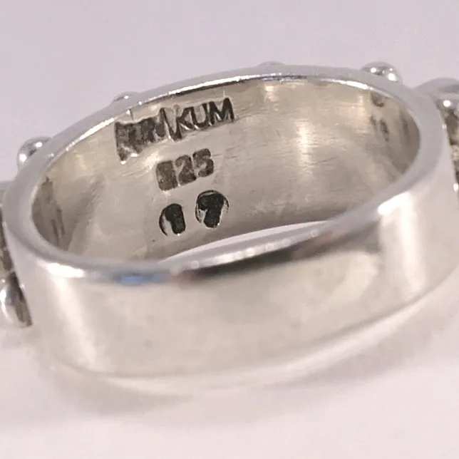 Kumkum ring, stämplad med 925 silver, loggan samt storleken (17). Viita glittrande stenar med äkta pärlor som dekoration. Ringen är 6mm bred på framsidan. Fraktkostnad tillkommer . Accessoarer.