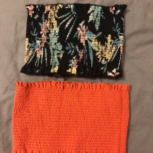 Bandeau toppar - Säljer dessa helt oanvända topparna i storlek S, då dem aldrig kommer till användning. Superfina och fräscha till sommaren. En svart med mönster & en coral färgad. Kan köpa båda två för 100kr eller var och en för 50kr. Köparen står för frakten:)