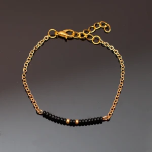  - Handgjort armband i guld och svart. Kedjan är justerbar. OBS guldfärgen är inte lika gul/orange som på bilden. Fri frakt vid köp över 100:-.