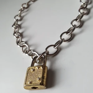  - Silverfärgat kedjehalsband med guldigt lås. Fraktkostnad blir 18kr. 