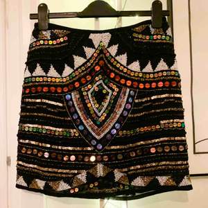 Paljett broderad kjol från River Island. Jättefint plagg som jag tyvärr inte använt, då den är köpt i för liten storlek. Mått: midja 72 cm, Längd mitt bak 43 cm. 