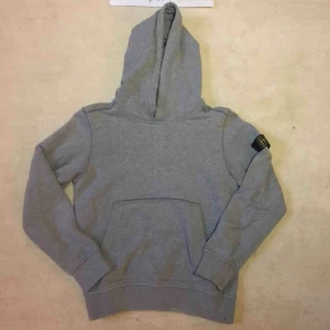  - Stone Island Junior hoodie, grå. Cond: 7/10, liten fläck som ska bli åtgärdad. Storlek: 142 men passar större