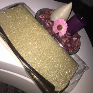 En helt ny guldig liten handväska, kan användas till fina fester och speciella tillfällen. Den är oöppnad.  