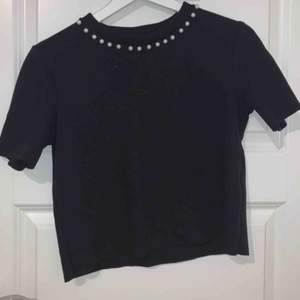 En svart snygg tröja med lite ”pärlor” på framsidan. Lite kort men längre än magtröja. Använd 1 gång & är som ny. Det går bra att buda :)