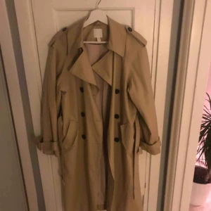  - Superfintrenchcoat från H&M i storlek 36. Använd ett fåtal gånger då jag hittade en 34a strax efter. Något oversized och superskönt material!   Frakt tillkommer.
