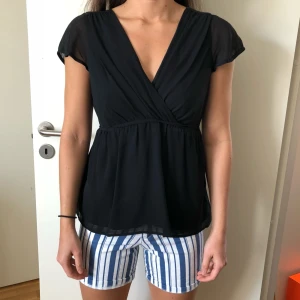  - Svart blus med knyt i ryggen