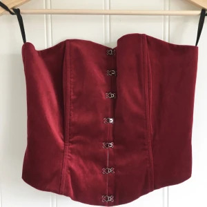  - Otroligt vacker djupröd sammets korsett med metall stavar insydd. Nyskick. Finns bilder där jag har den på i min Plick.