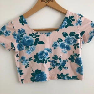  - Jättefin blommig topp/magtröja med kort ärm och djup ringning i ryggen och stretchigt tyg. Bra skick!