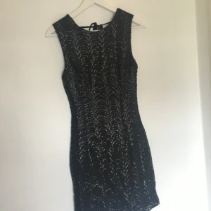  - Svart paljettklänning med öppen rygg och knytning i ryggen  