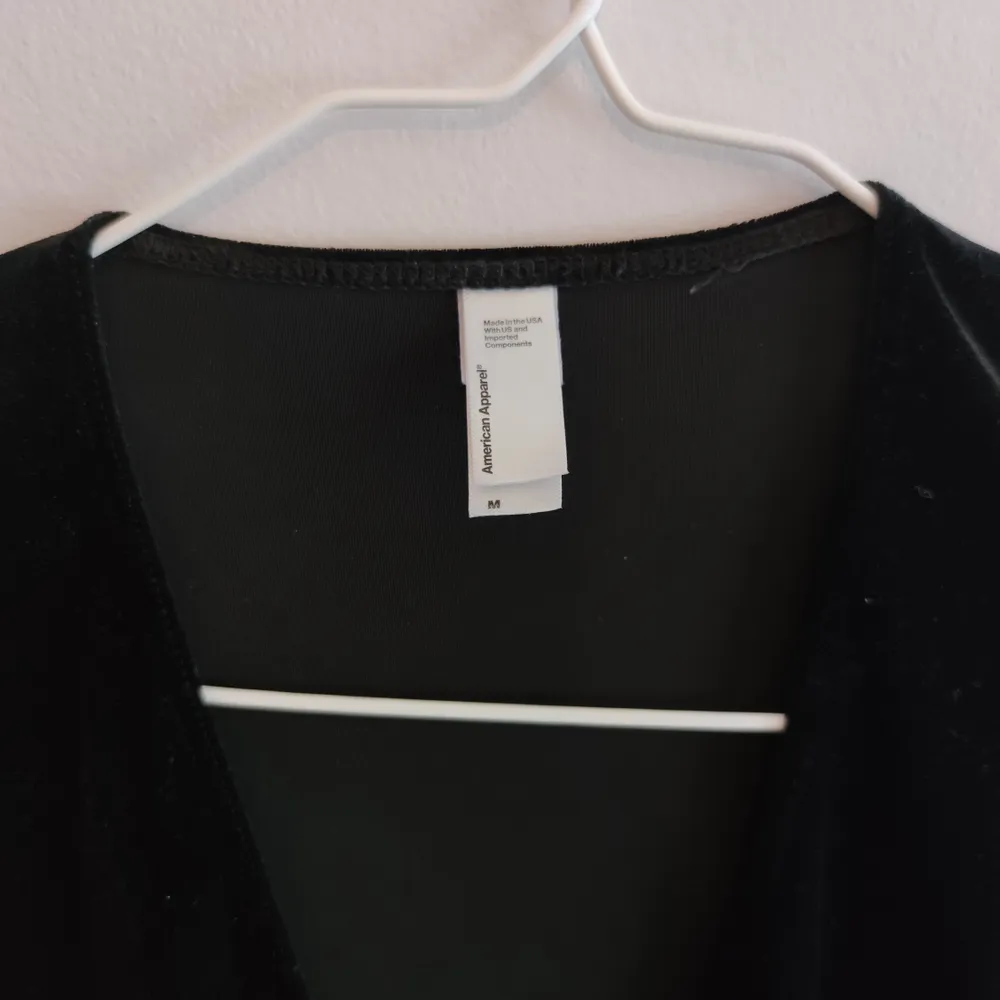 Klänning med djup v-ringning i svart sammet från American Apparel. Storlek M och i perfekt ny-skick! Skickar mot frakt på 40kr.. Klänningar.
