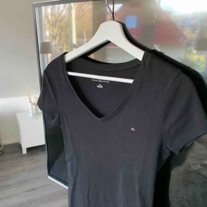  - Urringad svart T-shirt från Tommy hilfiger. 