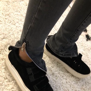 Gråa jeans - Gråa lågmidjade jeans med dragkedja slits nertill och detaljer, stretchiga passar bäst en xs💕🦋