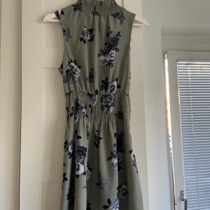 Grönblommig klänning från NAKD - Storlek XS. Men passar även S