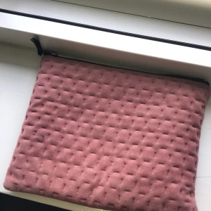 Sminkväska - En sminkväska i rosa brun färg med ett sträck mönster