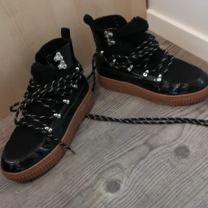 Gina tricot - Svarta vinterkängor. Mjukt och skönt tyg inuti och varma för vintern. Snygga detaljer med snörning som kan knytas på flera sätt. 