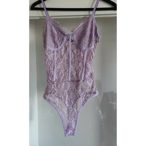 Lila spets Body  - En fin endast testad spets Body med extra tyg vid kuporna , knäpps med knappar vid grenen. Storlek 40 ,passar medium. Från tall kollektion och passar därför längre personer också.