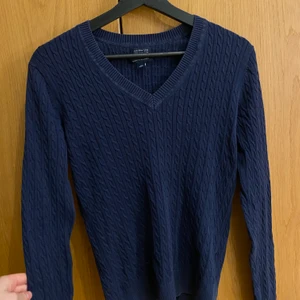 Marinblå kabelstickad tröja  - Super fin marin blå kabelstickad tröja med v-ringning från Tommy hilfiger (köpt i Tommy butik). Storlek S men passar även XS (ingen bild på pga för liten). Jätte fint skick✨ Nypris: 1125kr. Säljer för högsta bud eller 200kr utan frakt. Pris kan som vanligt diskuteras (lämna meddelande)💕