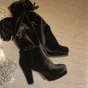 Knähöga klackar av sammet - Klackskor som slutar över knät, av sammet. Lite lös fram i sulan, men kan enkelt fixas med lite lim, eller låta det vara ( inget man märker)