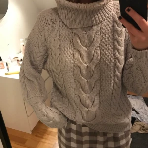 Stickad tröja Nakd - Grå kabelstickad med polo från Nakd. Använd Max 3 gånger så är i fint skick och passar till allt i princip.