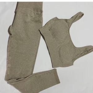 Träningstajts + topp - Jättefint  sätt köpt här på plick (oanvänd av förra ägaren och endast provade av mig). Beige isch färg. Tyvärr lite för liten då jag egentligen är en M men tog dessa i S. Ribbat material, jättesköna. Första bilden är lånad. Frakt tillkommer. Antingen köp för 350 eller starta budgivning från 200