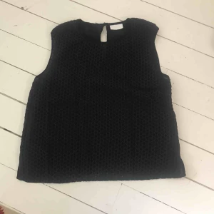  - Kortärmad topp med tunt sidentyg baktill. 