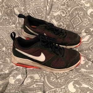  - Svarta Nike gympaskor med orange detaljer. Storlek 40