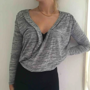  - Grå mönstrad tröja från bik bok som är korsad i fram. I gott skick. 